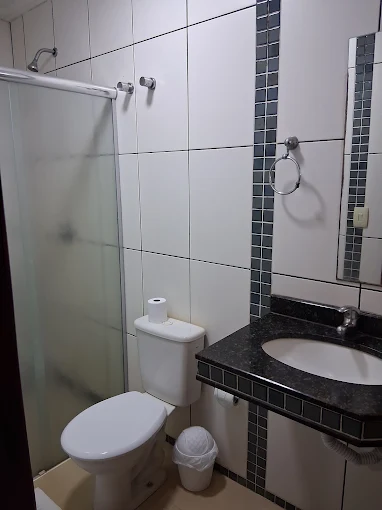 Banheiro com box de vidro e pia de granito